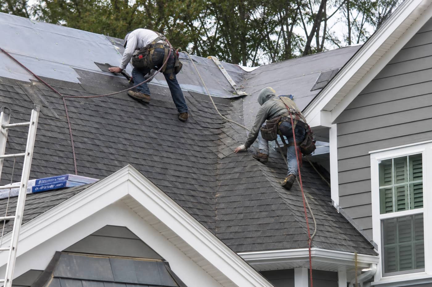 Roofing crew installing shingles on a Charlotte Metro home